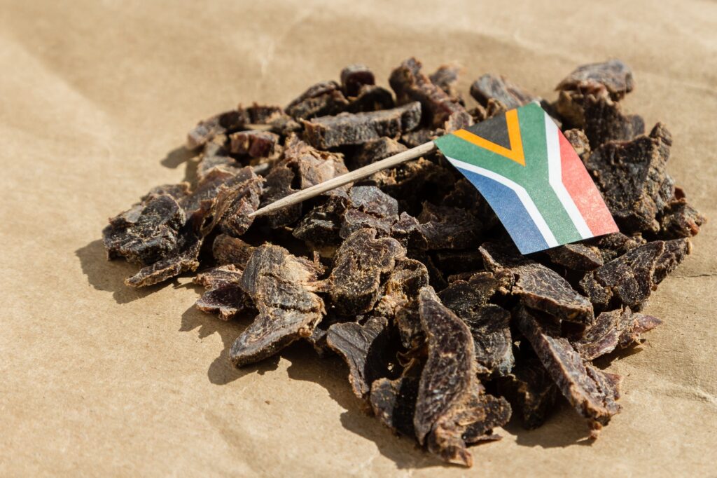 Flag of South Africa on traditional biltong snack on a wooden surface